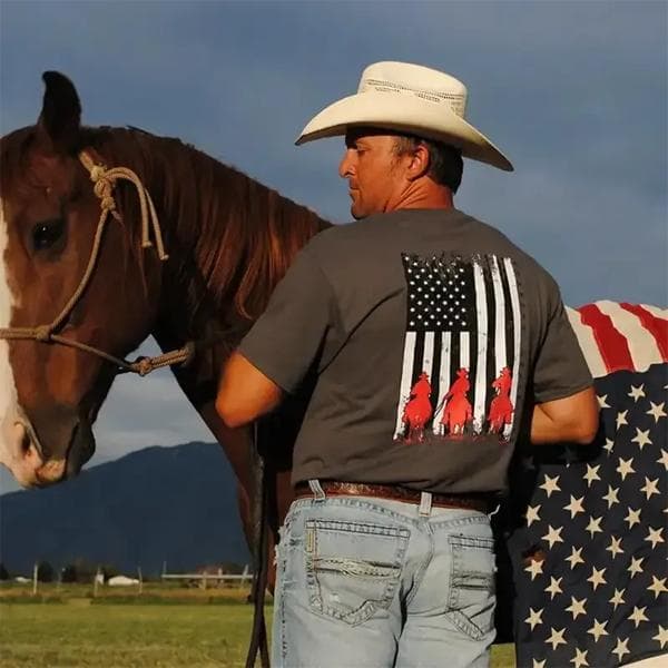 Millbrook Tack lifestyle image - Cowboy in a white hat standing with a brown horse in a field with mountains in the background.
