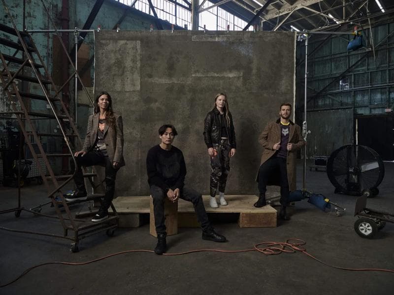 Nicholas Maggio - Group of four models in an industrial warehouse wearing patterned coats, leather jackets, and streetwear.